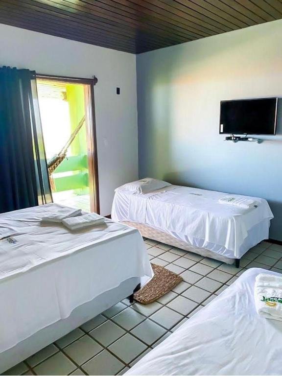Quarto do Sistcep Praia Hotel com camas e TV